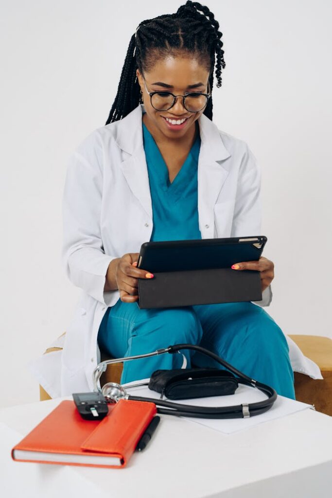 pexels photo 19957218 Black female doctor in scrubs using a tablet for virtual consultation indoors.