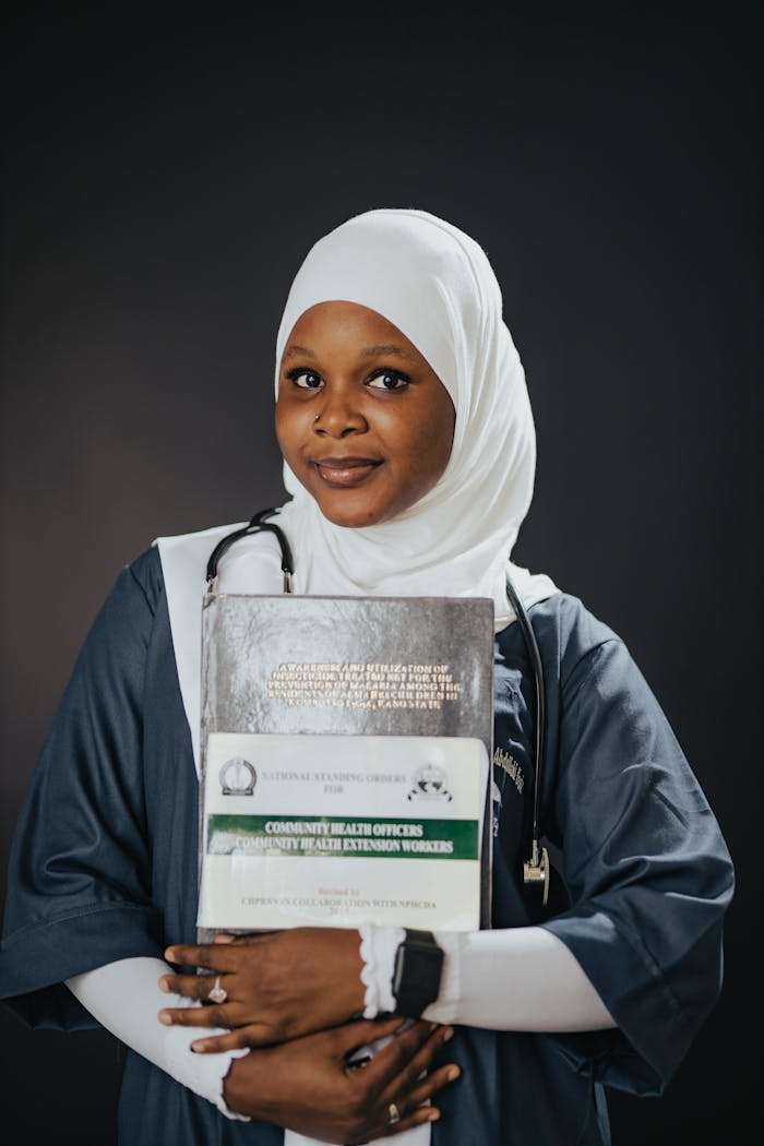 Confident young medical professional with books and stethoscope.